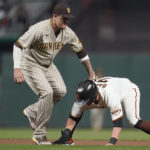 
              San Diego Padres third baseman Manny Machado, left, tags out San Francisco Giants' J.D. Davis on a double play hit into by Tommy La Stella during the seventh inning of a baseball game in San Francisco, Monday, Aug. 29, 2022. (AP Photo/Jeff Chiu)
            