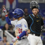 
              Los Angeles Dodgers' Mookie Betts (50) gestures after hitting a two-run home run in the seventh inning of a baseball game against the Miami Marlins, Friday, Aug. 26, 2022, in Miami. (AP Photo/Marta Lavandier)
            