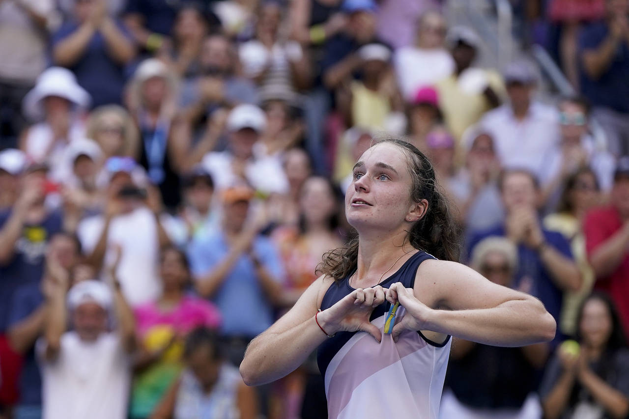 Daria Snigur, of Ukraine, reacts after upsetting Simona Halep, of Romania, during the first round o...
