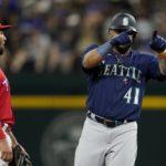 
              Seattle Mariners' Carlos Santana (41) celebrates his double next to Texas Rangers second baseman Marcus Semien during the fourth inning of a baseball game in Arlington, Texas, Friday, Aug. 12, 2022. (AP Photo/Tony Gutierrez)
            