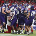 
              Northwestern running back Cam Porter, center, celebrates with teammates after scoring a on a 3-yard touchdown run during the second half of an NCAA college football game against Nebraska, Saturday, Aug. 27, 2022, at Aviva Stadium in Dublin, Ireland. (AP Photo/Peter Morrison)
            