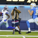 
              Dallas Cowboys' KaVontae Turpin, left, returns a punt for a touchdown past Los Angeles Chargers punter JK Scott (16) during the first half of a preseason NFL football game Saturday, Aug. 20, 2022, in Inglewood, Calif. (AP Photo/Ashley Landis )
            
