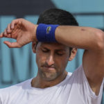 
              FILE - Novak Djokovic, of Serbia, wipes the sweat off during a training session at the Mutua Madrid Open tennis tournament in Madrid, Spain, on April 30, 2022.  Djokovic withdrew from the upcoming hard-court tournament in Montreal on Thursday, AUg. 4, 2022,  because he is not vaccinated against COVID-19 and is therefore not allowed to enter Canada. (AP Photo/Manu Fernandez, File)
            