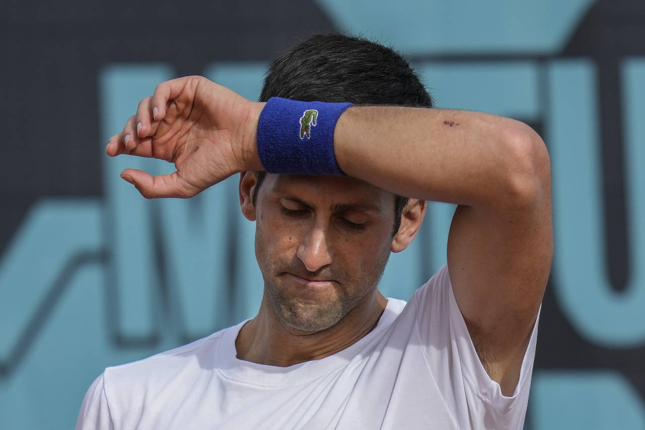 FILE - Novak Djokovic, of Serbia, wipes the sweat off during a training session at the Mutua Madrid...