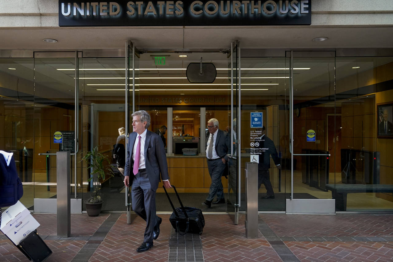 Robert Walters, center, an attorney representing three LIV Golf players, leaves a federal courthous...