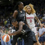 
              Seattle Storm guard Jewell Loyd (24) gets the rebound and makes a break around Storm center Tina Charles (31) as Washington Mystics center Shakira Austin (0) watches during the first half of Game 1 of a WNBA basketball first-round playoff series Thursday, Aug. 18, 2022, in Seattle. (AP Photo/Lindsey Wasson)
            