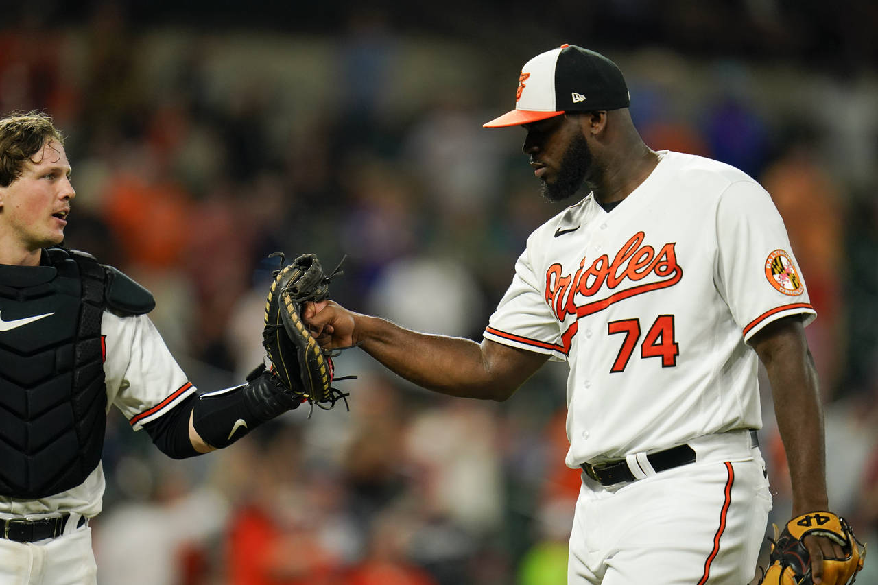 Baltimore Orioles relief pitcher Felix Bautista (74) gives a fist bump to the glove of catcher Adle...