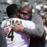 
              Oakland Athletics executive vice president of baseball operations Billy Beane, facing, hugs former player Miguel Tejada as the Athletics honor their 2002 team before a baseball game between the Athletics and the New York Yankees in Oakland, Calif., Sunday, Aug. 28, 2022. (AP Photo/Jeff Chiu)
            
