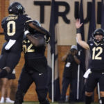 
              Wake Forest running back Christian Turner (0) celebrates his touchdown against VMI with teammates DeVonte Gordon (62) and Mitch Griffis (12) during the first half of an NCAA college football game in Winston-Salem, N.C., Thursday, Sept. 1, 2022. (AP Photo/Chuck Burton)
            