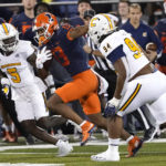 
              Illinois wide receiver Pat Bryant (13) advances the ball off a pass from quarterback Tommy DeVito as Chattanooga's CaMiron Smith (5) and Marlon Taylor pursue during the first half of an NCAA college football game Thursday, Sept. 22, 2022, in Champaign, Ill. (AP Photo/Charles Rex Arbogast)
            