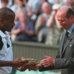 
              FILE - MaliVai Washington, of the United States, receives the runners-up plate from the Duke of Kent, following the men's singles tennis final at Wimbledon, on July 7, 1996. Frances Tiafoe is the first man from the United States to reach the semifinals at the U.S. Open in 16 years. And he could become the first Black man from the U.S. in a major final since MaliVai Washington was the runner-up at Wimbledon in more than a quarter-century ago.  (AP Photo/Gill Allen, File)
            