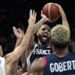 
              Evan Fournier of France, center, is challenged by Spain's Xabier Lopez-Arostegui, left, during the Eurobasket final basketball match between Spain and France in Berlin, Germany, Sunday, Sept. 18, 2022. (AP Photo/Michael Sohn)
            