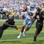 
              North Carolina quarterback Drake Maye (10) runs in for the two-point conversion between Appalachian State linebacker Nick Hampton (9) and linebacker Trey Cobb (7) during the second half of an NCAA college football game, Saturday Sept. 3, 2022, in Boone, N.C. (AP Photo/Reinhold Matay)
            