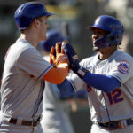
              New York Mets Mark Canha, left, and Francisco Lindor (12) celebrate after scoring in the eighth inning of a baseball game against the Oakland Athletics in Oakland, Calif., on Sunday, Sept. 25, 2022. (AP Photo/Scot Tucker)
            