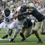 
              Wake Forest running back Justice Ellison, center, is hit by Vanderbilt cornerback Tyson Russell, right, in the second half of an NCAA college football game Saturday, Sept. 10, 2022, in Nashville, Tenn. (AP Photo/Mark Humphrey)
            