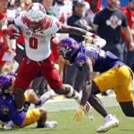 
              North Carolina State's Demie Sumo-Karngbaye (0) tries to run the ball between East Carolina's Teagan Wilk (9) and Damel Hickman (23) during the first half of an NCAA college football game in Greenville, N.C., Saturday, Sept. 3, 2022. (AP Photo/Karl B DeBlaker)
            
