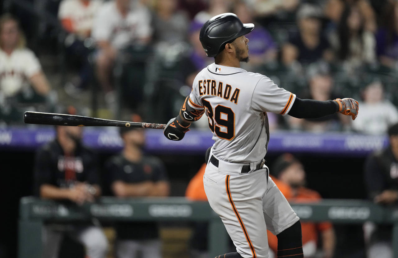 San Francisco Giants' Thairo Estrada follows the flight of his three-run home run off Colorado Rock...