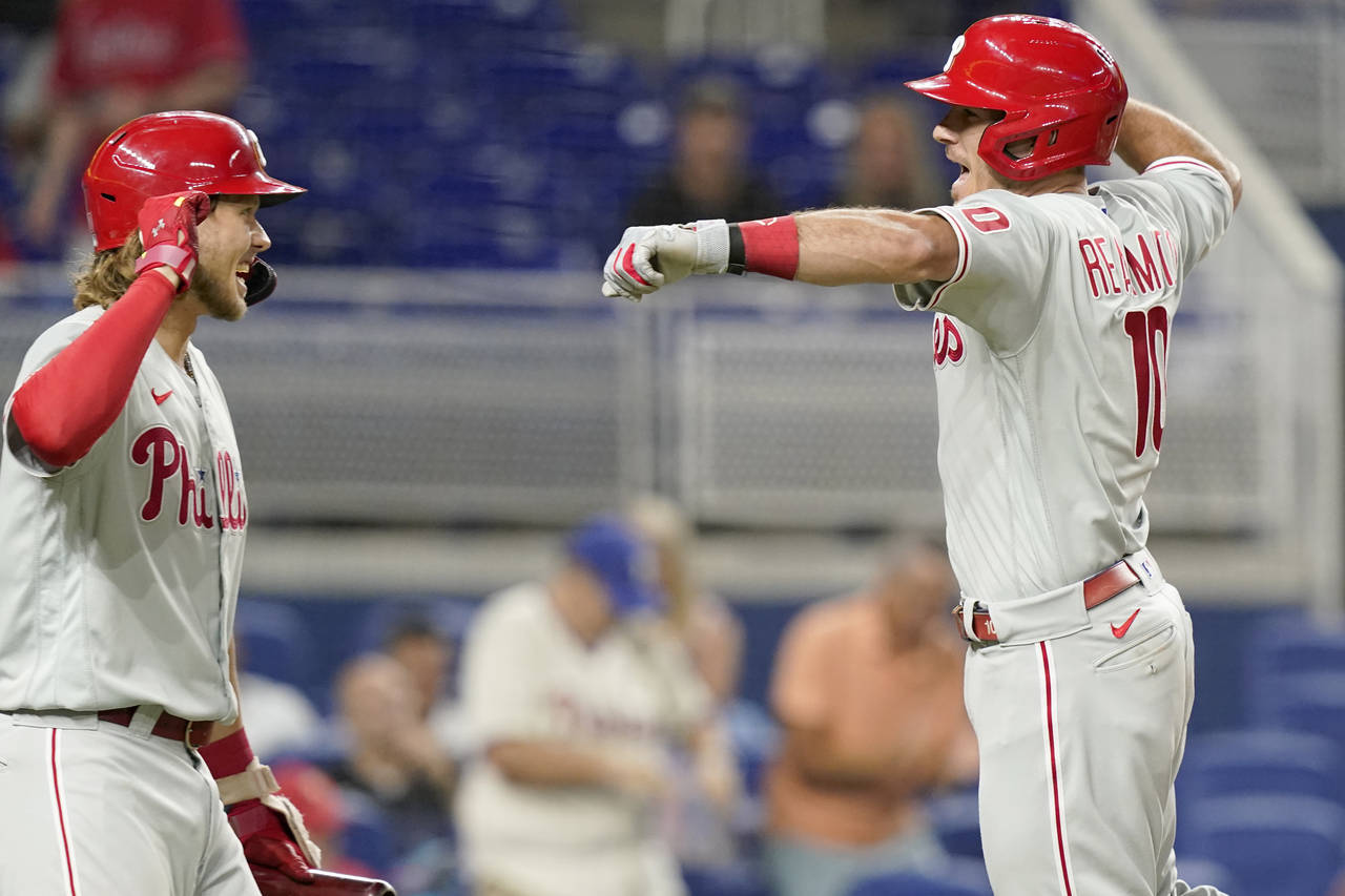 Philadelphia Phillies' J.T. Realmuto (10) celebrates with Alec Bohm after scoring on a solo home ru...