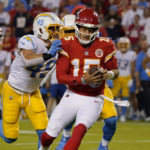 
              Kansas City Chiefs quarterback Patrick Mahomes, right, is sacked by Los Angeles Chargers linebacker Drue Tranquill (49) during the first half of an NFL football game Thursday, Sept. 15, 2022, in Kansas City, Mo. (AP Photo/Ed Zurga)
            