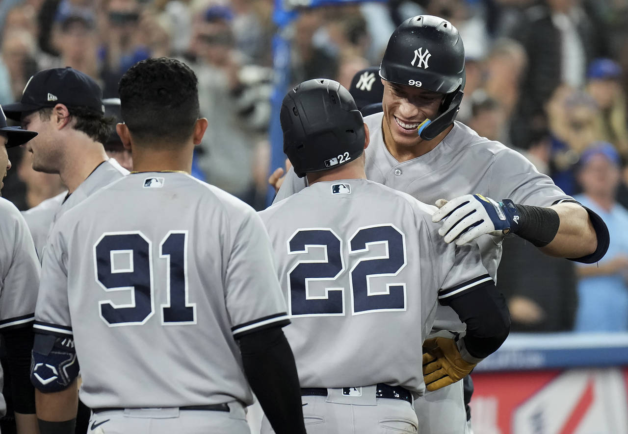 New York Yankees' Aaron Judge, right, is congratulated by teammates, including Harrison Bader (22),...