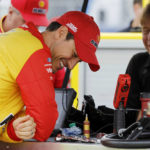 
              Joey Logano, left, reacts on pit road before the start of practice for a NASCAR Cup Series auto race at Kansas Speedway in Kansas City, Kan., Saturday, Sept. 10, 2022. (AP Photo/Colin E. Braley)
            