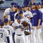 
              Members of the Los Angeles Dodgers, including Max Muncy (13) congratulate each other after they defeated the San Francisco Giants 6-3 in a baseball game Tuesday, Sept. 6, 2022, in Los Angeles. (AP Photo/Mark J. Terrill)
            