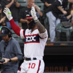 
              Chicago White Sox's Yoan Moncada (10) gestures as he crosses home plate after hitting a home run against the Detroit Tigers during the fourth inning of a baseball game Sunday, Sept. 25, 2022, in Chicago. (AP Photo/David Banks)
            