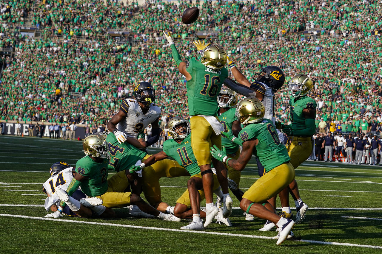 Notre Dame safety Brandon Joseph and California wide receiver Mavin Anderson (11) leap for a tipped...