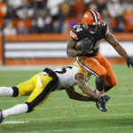 
              Cleveland Browns running back Nick Chubb (24) leaps out of a tackle attempt by Pittsburgh Steelers cornerback Ahkello Witherspoon (25) during the first half of an NFL football game in Cleveland, Thursday, Sept. 22, 2022. (AP Photo/Ron Schwane)
            