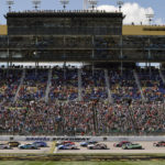 
              Racers head toward Turn 1 at the start of a NASCAR Cup Series auto race at Kansas Speedway in Kansas City, Kan., Sunday, Sept. 11, 2022. (AP Photo/Colin E. Braley)
            