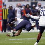 
              Chicago Bears quarterback Justin Fields, left, is tripped up by offensive tackle Braxton Jones (70) during the first half of an NFL football game against the Houston Texans Sunday, Sept. 25, 2022, in Chicago. (AP Photo/Charles Rex Arbogast)
            