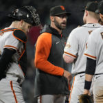 
              San Francisco Giants manager Gabe Kapler, center left, confers with starting pitcher Logan Webb, center right, before pulling him from the mound during the sixth inning of the team's baseball game against the Colorado Rockies on Wednesday, Sept. 21, 2022, in Denver. (AP Photo/David Zalubowski)
            