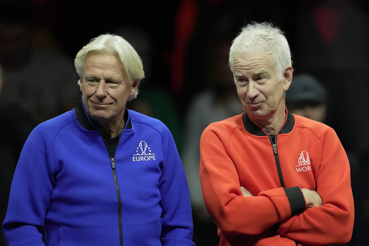 Team Europe's Captain Bjorn Borg, left, chats with Team World's captain John McEnroe, on the second...