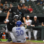 
              Toronto Blue Jays' Alejandro Kirk scores against Baltimore Orioles catcher Adley Rutschman during the second inning of a baseball game, Tuesday, Sept. 6, 2022, in Baltimore. (AP Photo/Terrance Williams)
            