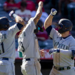 
              Seattle Mariners' Carlos Santana, left, and J.P. Crawford, center, congratulate Ty France, right, for hitting a three-run home run against the Los Angeles Angels during the seventh inning of a baseball game in Anaheim, Calif., Monday, Sept. 19, 2022. (AP Photo/Alex Gallardo)
            