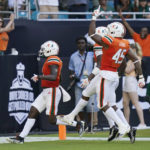 
              Miami defensive lineman Mitchell Agude (45) celebrates as defensive back Gilbert Frierson, left, scores a touchdown after intercepting the ball during the first half of an NCAA college football game against Bethune Cookman, Saturday, Sept. 3, 2022, in Miami Gardens, Fla. (AP Photo/Lynne Sladky)
            