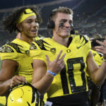 
              Oregon quarterback Ty Thompson (13) jokes with quarterback Bo Nix (10) after the team's 70-14 win over Eastern Washington in an NCAA college football game Saturday, Sept. 10, 2022, in Eugene, Ore. (AP Photo/Andy Nelson)
            