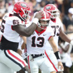 
              Georgia offensive lineman Amarius Mims (65) congratulates quarterback Stetson Bennett (13) during the first half of an NCAA college football game against South Carolina on Saturday, Sept. 17, 2022, in Columbia, S.C. (AP Photo/Artie Walker Jr.)
            