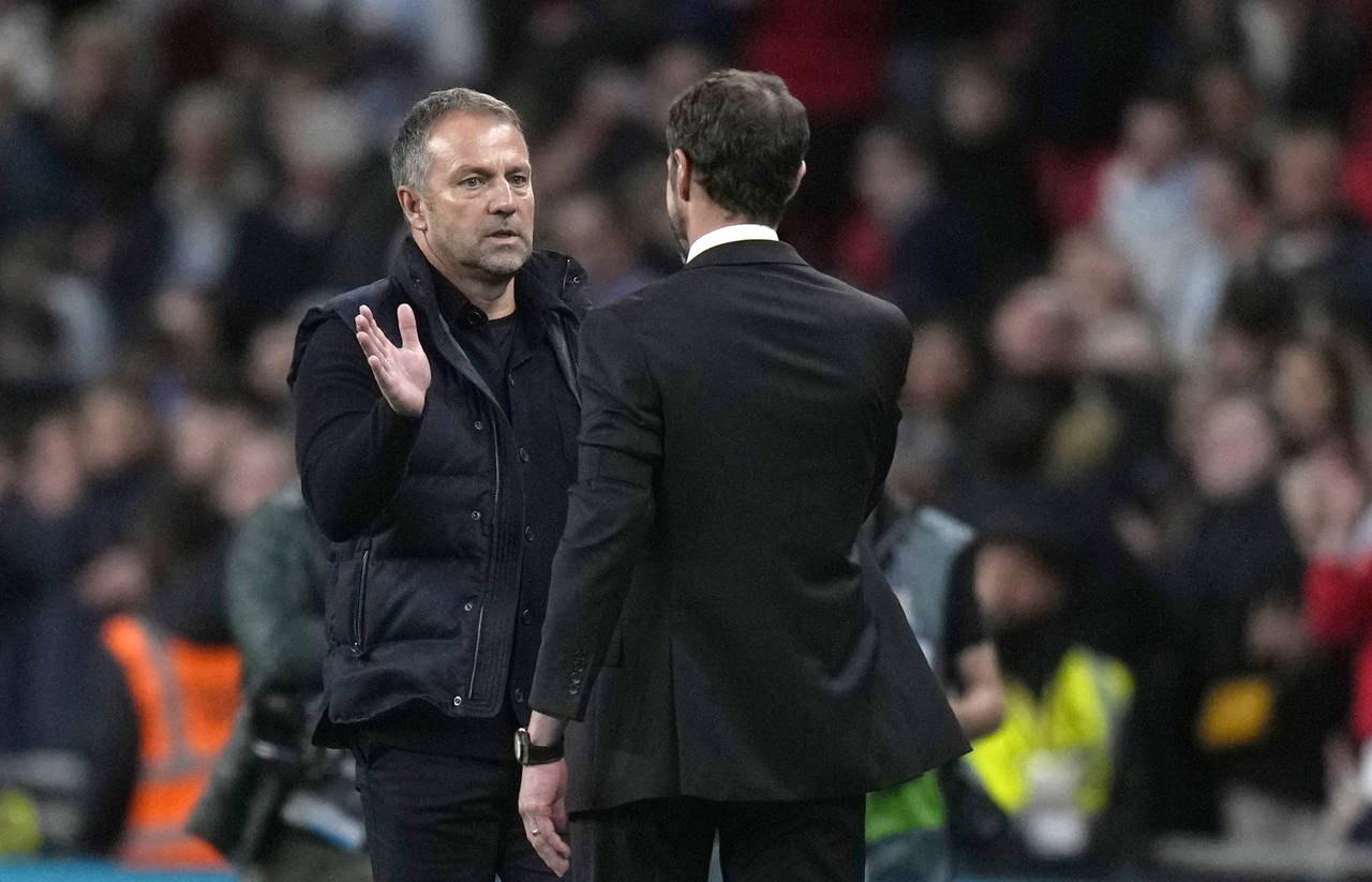 Germany's head coach Hans-Dieter Flick, left, shakes hands with England's head coach Gareth Southga...