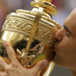 
              FILE - Switzerland's Roger Federer kisses the trophy after defeating Croatia's Marin Cilic to win the Men's Singles final match on day thirteen at the Wimbledon Tennis Championships in London Sunday, July 16, 2017. Federer announced Thursday, Sept.15, 2022 he is retiring from tennis. (AP Photo/Alastair Grant, File)
            