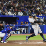 
              New York Yankees' Aaron Judge (99) flies out, next to Toronto Blue Jays catcher Danny Jansen during the second inning of a baseball game Wednesday, Sept. 28, 2022, in Toronto. (Nathan Denette/The Canadian Press via AP)
            