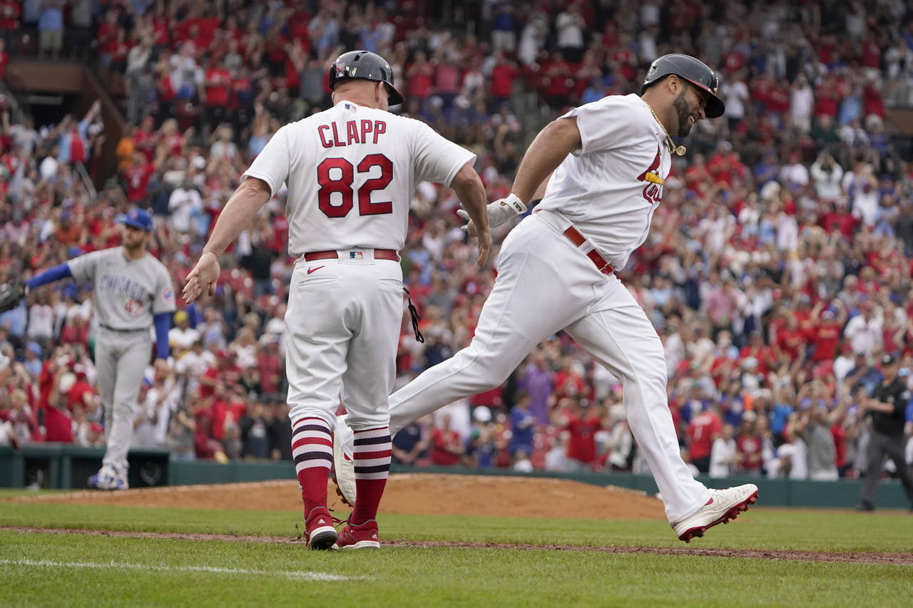 St. Louis Cardinals' Albert Pujols, right, is congratulated by first base coach Stubby Clapp (82) a...