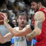 
              Slovenia's Goran Dragic, left, is challenged by Poland's Dominik Olejniczak, right, during the Eurobasket quarter final basketball match between Slovenia and Poland in Berlin, Germany, Wednesday, Sept. 14, 2022. (AP Photo/Michael Sohn)
            