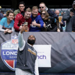 
              FILE - Miami Dolphins defensive end Christian Wilkins (94) takes a selfie with fans before the team's NFL football game against the Jacksonville Jaguars at Tottenham Hotspur Stadium in London, Oct. 17, 2021. fFolks in soccer-mad Britain have a growing hankering for the U.S. brand of football, brought to their world with a big push from the NFL and an increasingly diverse media landscape. “It's a good sport. It's got violence. It's got scoring,” said Joe Vincent, a Welshman who set up the Jacksonville Jaguars fan club in Britain. “Once you've gone to a game, you're hooked.” (AP Photo/Steve Luciano, File)
            