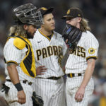 
              San Diego Padres relief pitcher Josh Hader, right, talks on the mound with third baseman Manny Machado, center, and catcher Jorge Alfaro after Los Angeles Dodgers' Trea Turner scored the tying run on a passed ball during the ninth inning of a baseball game Tuesday, Sept. 27, 2022, in San Diego. (AP Photo/Gregory Bull)
            