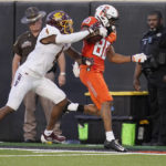 
              Oklahoma State wide receiver Brennan Presley (80) is pushed out of bounds by Central Michigan defensive back Donte Kent (4) during the first half of an NCAA college football game Thursday, Sept. 1, 2022, in Stillwater, Okla. (AP Photo/Sue Ogrocki)
            