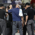 
              Home plate umpire Mark Ripperger receives attention after being injured during the ninth inning of a baseball game between the Atlanta Braves and the Miami Marlins on Saturday, Sept. 3, 2022, in Atlanta. Ripperger left the game. (AP Photo/Bob Andres)
            