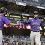 
              Colorado Rockies' Ryan McMahon (24) is congratulated by Elias Diaz (35) after McMahon scored against the San Francisco Giants during the first inning of a baseball game in San Francisco, Tuesday, Sept. 27, 2022. (AP Photo/John Hefti)
            