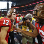 
              Georgia quarterback Stetson Bennett and running back Kenny McIntosh put on old leather helmets while celebrating a 49-3 victory over Oregon in an NCAA college football game on Saturday, Sept. 3, 2022, in Atlanta. (Curtis Compton/Atlanta Journal-Constitution via AP)
            