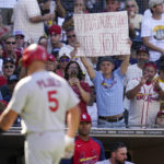 
              A fan holds a sign as St. Louis Cardinals' Albert Pujols walks back to the dugout after flying out during the eighth inning of a baseball game against the San Diego Padres, Thursday, Sept. 22, 2022, in San Diego. (AP Photo/Gregory Bull)
            